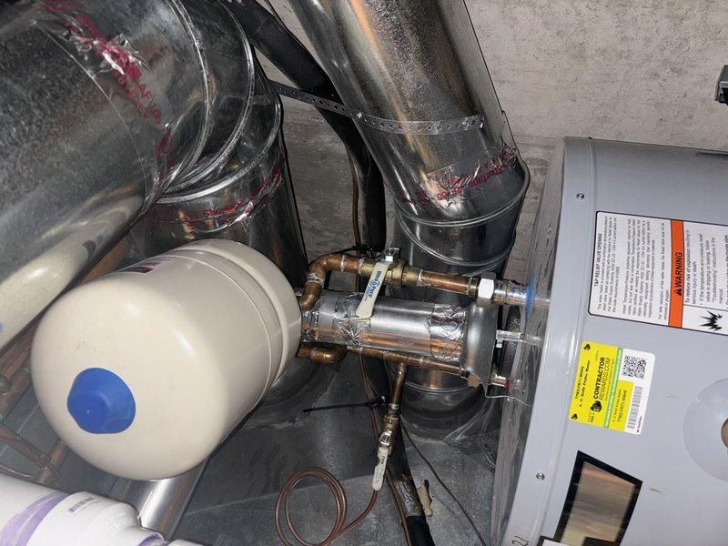 Responded to reported leak on A.O. Smith LineMaster commercial grade tank water heater installed in basement utility area. Performed diagnostic inspection of unit and associated plumbing connections, including expansion tank, copper supply lines, brass fittings, and pressure relief components. Assessed water heater system condition, checked all visible connections and joints for active leakage, and documented equipment installation configuration with HVAC ductwork and integrated mechanical systems.