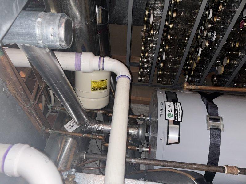 Responded to reported leak on A.O. Smith LineMaster commercial grade tank water heater installed in basement utility area. Performed diagnostic inspection of unit and associated plumbing connections, including expansion tank, copper supply lines, brass fittings, and pressure relief components. Assessed water heater system condition, checked all visible connections and joints for active leakage, and documented equipment installation configuration with HVAC ductwork and integrated mechanical systems.