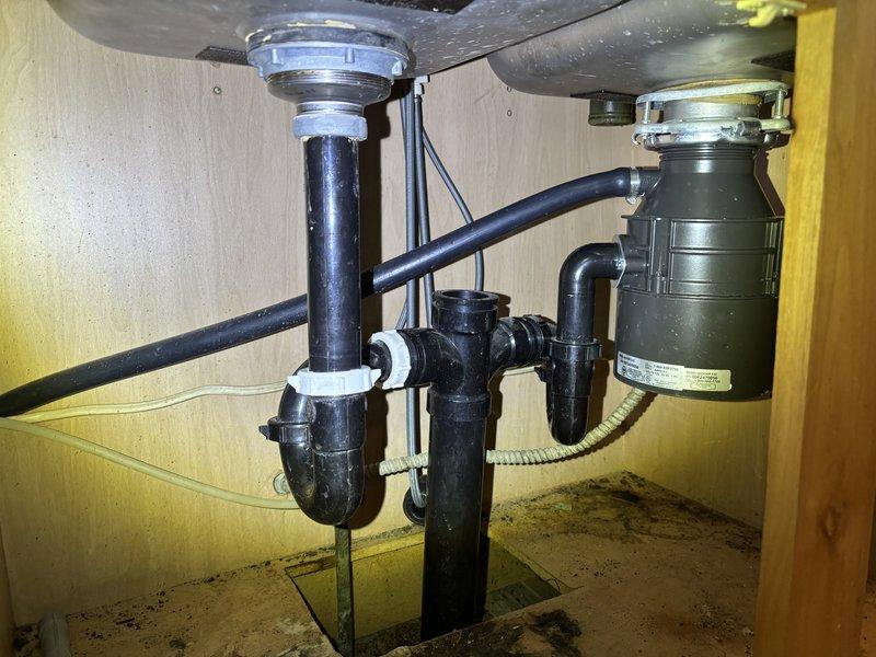 Responded to service call for slow-draining double-basin kitchen sink. Accessed plumbing assembly beneath sink and removed P-trap to clear blockage in drain line. Snaked kitchen drain through cleanout accessible under sink cabinet, successfully removing obstruction causing drainage issue. Reassembled P-trap and drainage components, tested both basins for proper flow, and confirmed all connections were secure with no leaks.