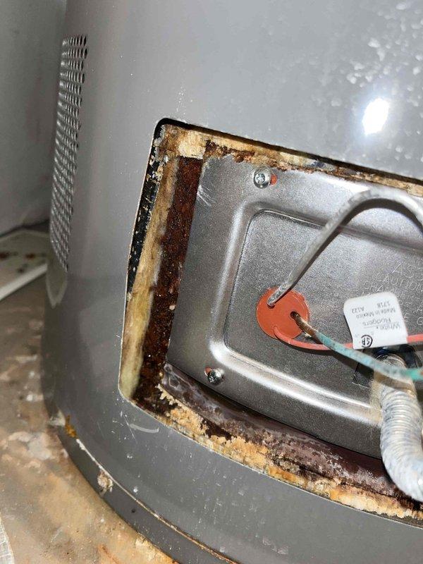 Performed a plumbing maintenance inspection including a system pressure test, water purity test, and water heater flush. Inspected the water heater and found deteriorated insulation and rust staining with mineral deposits around the lower element access panel, indicating possible moisture intrusion or corrosion at the element cover plate. Operated the tub fixtures and confirmed proper water flow at the spout.