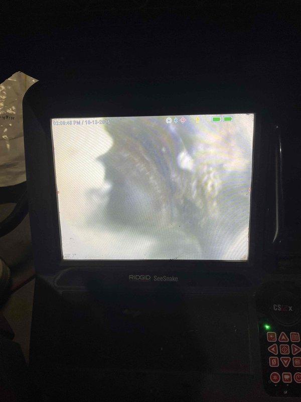 Responded to a sewer backup affecting multiple basement fixtures, including the mechanical room floor drain, shower, and tub, with active water discharge. Performed a sewer camera inspection of the drain line to assess the blockage and condition of the piping. Documented a damp, stained slab and a visible crack in the basement floor near the cast iron drain stack and floor drain.
