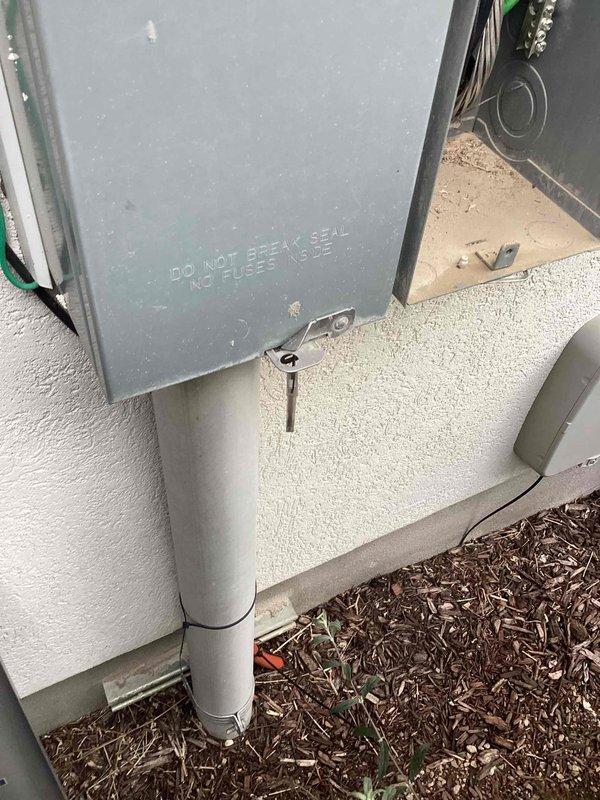 Performed a Green Shield electrical membership inspection, including a visual assessment of the exterior service equipment, utility meter enclosures, conduit runs, and wall-mounted electrical units. Documented the condition of the enclosures and inverter unit with photos, noting dust and sand accumulation inside an open, empty enclosure and minor surface wear on the metal housings. Reported doorbell-to-speaker connection concerns were reviewed as part of the visit.