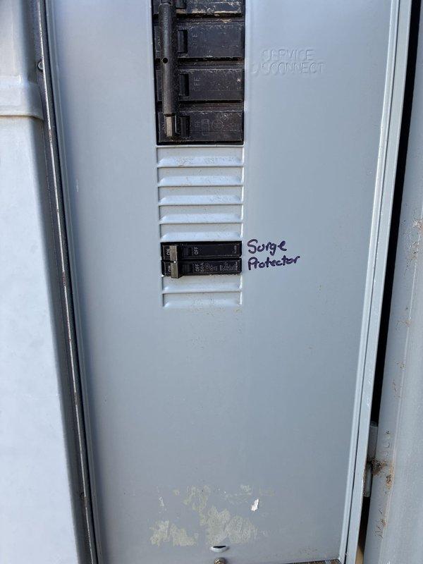 Installed a whole-home surge protective device at the outdoor service disconnect, landing conductors on a dedicated 50A two-pole breaker and connecting to the ground bar. Verified secure terminations, cleaned debris and cobwebs from the enclosure interior, and labeled the surge protector breaker at the panel door for future identification.