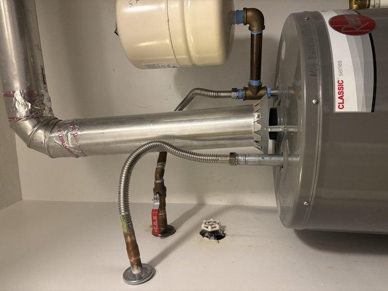 Diagnosed a Rheem Classic series tank-type gas water heater that was not producing hot water and displaying a seven-flash fault code indicating a thermostat/gas control valve failure. Disconnected the venting, gas flex connector, and water supply connections, including the expansion tank piping and shutoff valve, to remove the failed unit. Prepared the work area for replacement, with the existing flue, expansion tank, and supply lines inspected and found free of visible leaks, heavy corrosion, or damage.