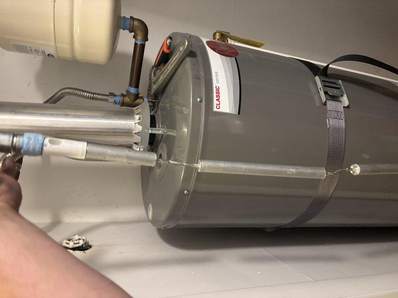Diagnosed a Rheem Classic series tank-type gas water heater that was not producing hot water and displaying a seven-flash fault code indicating a thermostat/gas control valve failure. Disconnected the venting, gas flex connector, and water supply connections, including the expansion tank piping and shutoff valve, to remove the failed unit. Prepared the work area for replacement, with the existing flue, expansion tank, and supply lines inspected and found free of visible leaks, heavy corrosion, or damage.