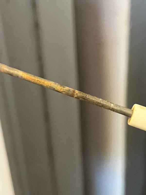 Performed a heating diagnostic on a partially operational gas furnace and conducted a combustion analysis, which recorded O2 at 7.4%, CO at 47 ppm, CO2 at 7.7%, and a flue gas temperature of 105.4°F. Inspection revealed a heavily corroded flame sensor rod with rust and pitting, indicating it requires cleaning or replacement to restore proper flame sensing and reliable furnace operation.