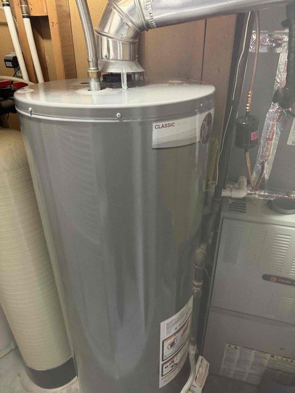Responded to a no-hot-water complaint on a standard gas-fired tank water heater, 6+ years old, and inspected the unit, gas supply, venting, and water connections. No leaks, corrosion, or visible damage were found, and the flexible water connectors, angled exhaust vent, and gas piping were intact. The unit was evaluated for pilot light/ignition failure and proper operation was addressed to restore hot water.