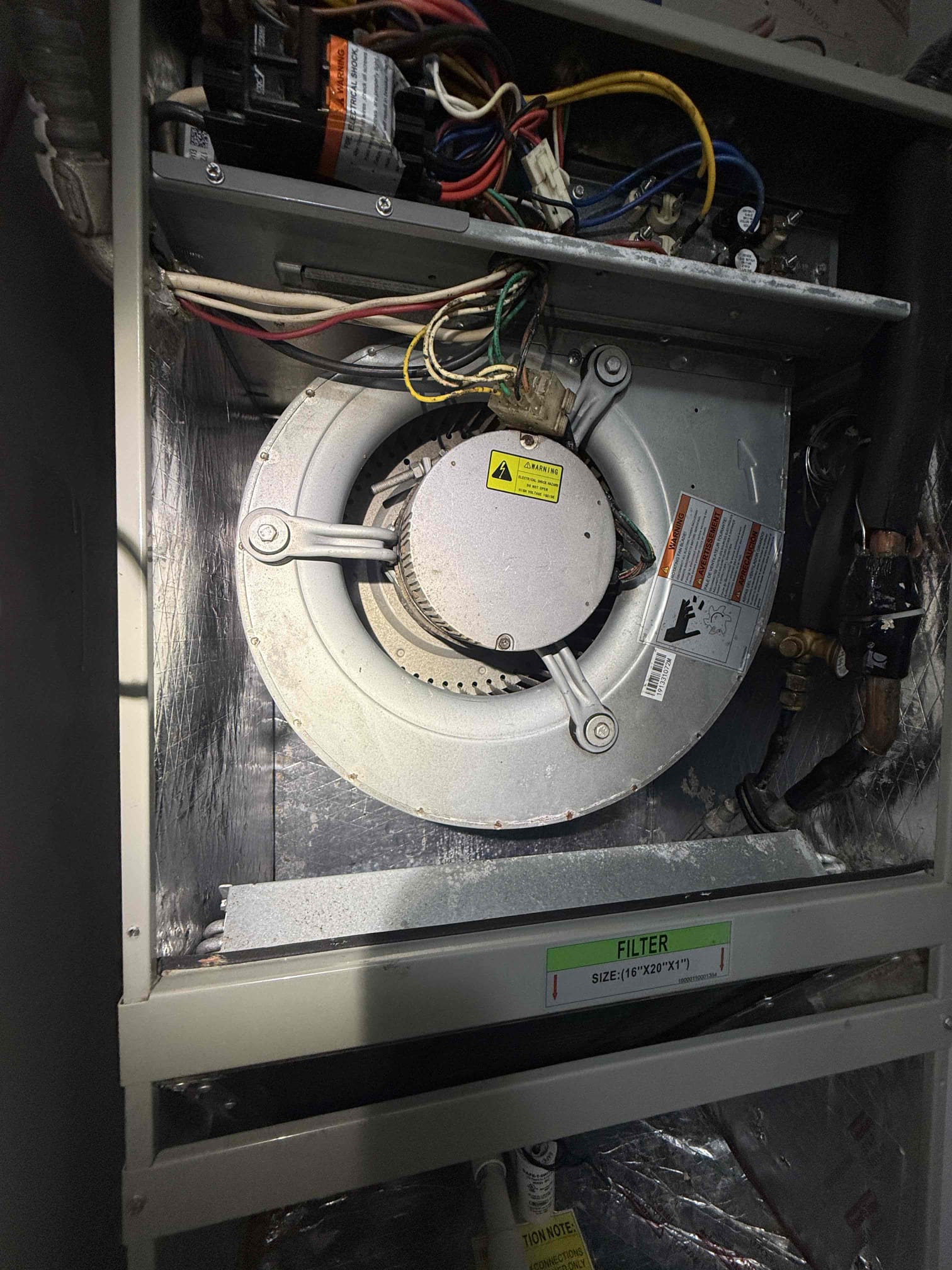 Upon my inspection, found water saturated insulation on bottom of unit. Opened unit and found insulation on back of unit is detached completely and choking off the fan motor. This is causing excess condensation within the unit. Blower will need to be pulled and insulation fastened back to the unit. 
Performed repair and system is cooling properly at this time. Checked condenser for amp draws and capacitor. Cleaned drain line complimentary. Advised client to keep fan on for 3 days and then return to the auto position to help remove water from soaked insulation. 