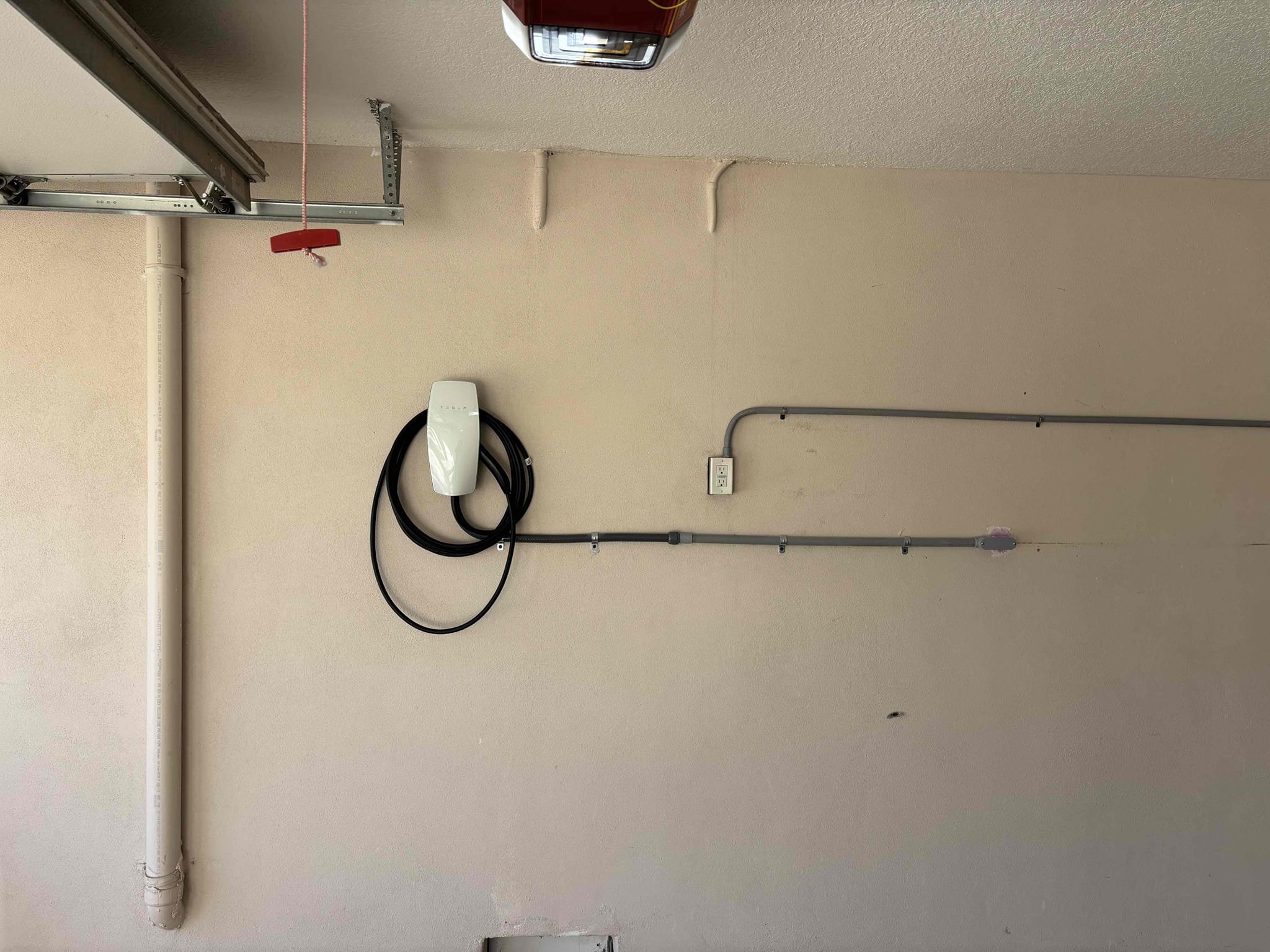 Install electrical for Tesla car charger in garage 
Run conduit to exterior panel 
Make space inside of panel for 2 pole breaker 