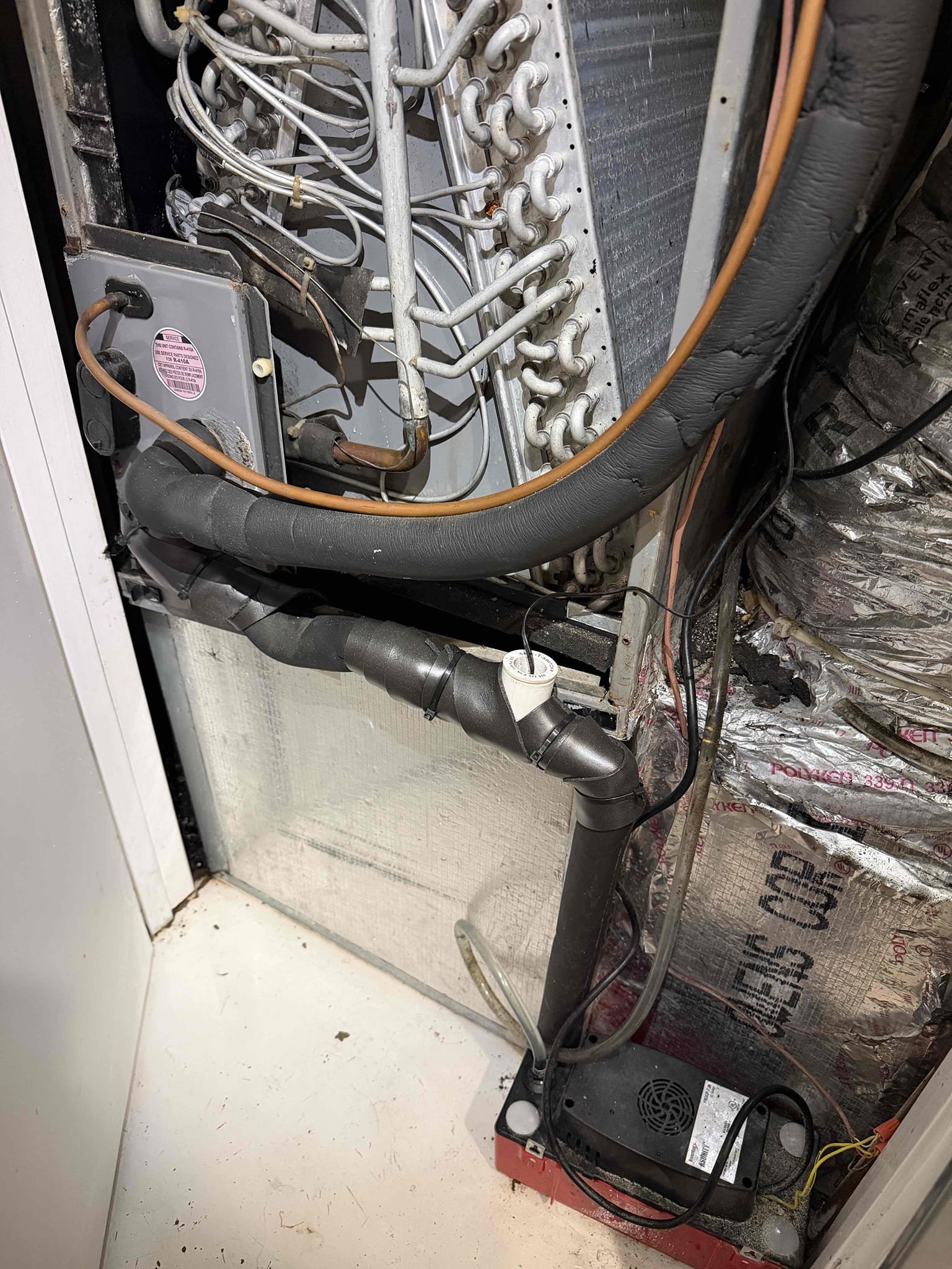 Upon my inspection, found severely clogged drain line. Also found safety float switch was on wrong side of the p trap which was not allowing for power to be cut to the system and turn it off before flooding the floor. 
Removed full drain line and replaced with new. Installed existing safety float switch on proper side of the p trap. Installed a clean out port so that the client can pour their vinegar down the drain if they would like to. 
Tested drainage. System is cooling and draining properly at this time. 