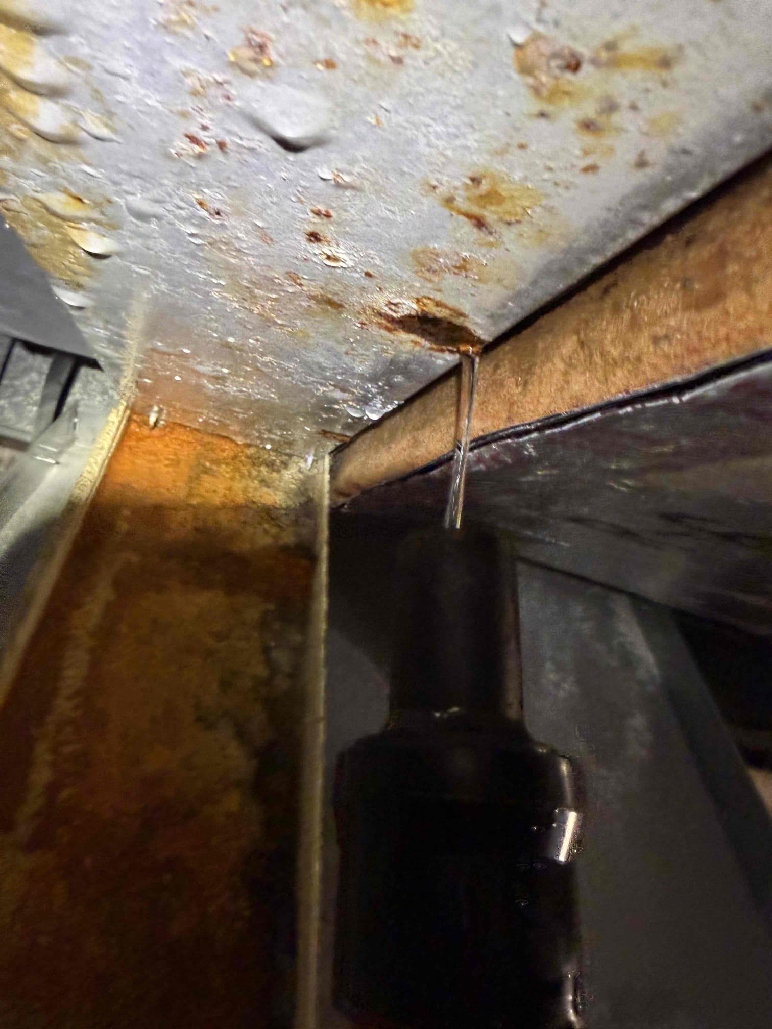 Upon my inspection, found main evaporator metal drip pwn clogged with rust and debris. Performed a pan removal and cleaning on unit. System is now draining properly. 