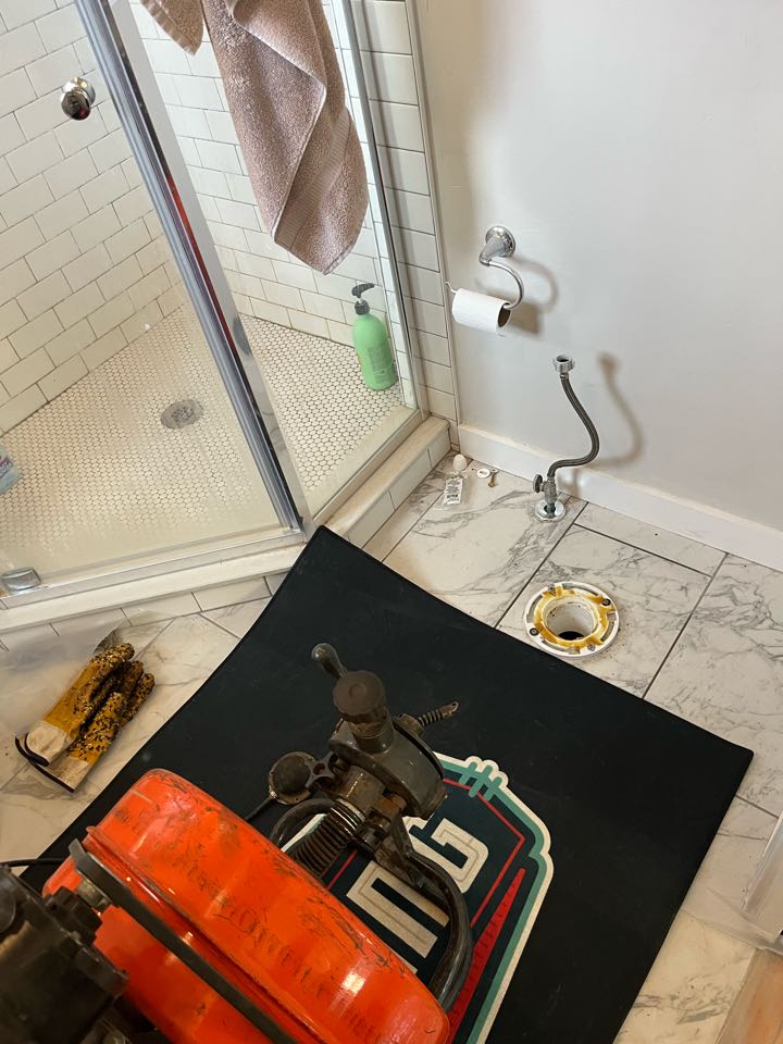 Pulled and reset commode and ran sewer machine through commode, stack, and cleared stoppage