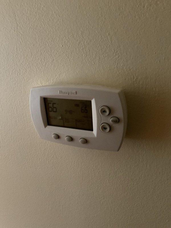 Conducted sales consultation for replacement of aging two-stage Armstrong gas belt furnace. Inspected existing installation environment, noting PVC plumbing runs and current thermostat setup (Honeywell digital displaying 66°F). Customer presented with options for new furnace system to replace the older unit.