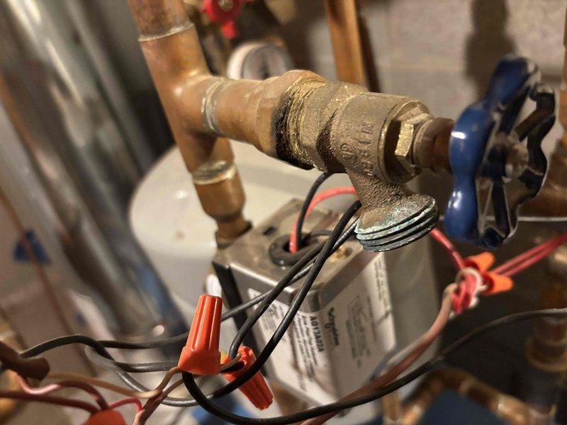 Responded to customer call regarding a slow boiler leak. Upon inspection, identified corrosion and deterioration at brass valve fitting connection with visible moisture present. Repaired threaded connection by replacing valve assembly and ensuring proper seal to eliminate leak.