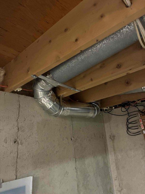 Repaired disconnected heating duct system by replacing a damaged 90-degree elbow that had separated from trunk line. Properly secured the ductwork to floor joists to prevent future displacement and ensure proper airflow through the system.