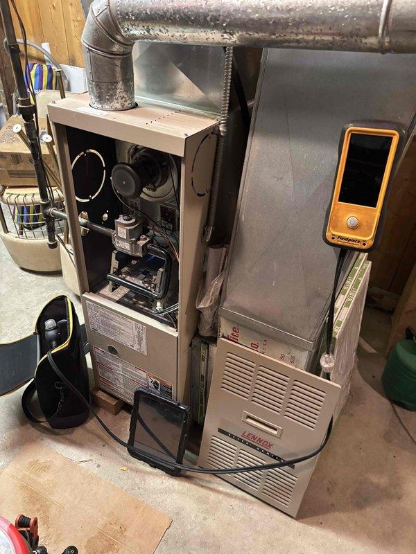 Responded to emergency service call for a 20-year-old Lennox furnace that had intermittent operation with low flame sense error code. Diagnostic testing with digital thermometers confirmed improper heating performance with readings of 61.6°F and 62°F. Performed maintenance by cleaning flame sensor, which resolved the no-heat condition and restored proper system operation.