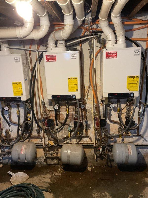 Responded to service call for leaking valve on Challenger boiler system. Upon inspection, found water accumulation near the unit's base connection points. Replaced faulty valve and checked operation of the integrated tankless water heater system with three units and expansion tanks. System now operating within normal parameters with no leaks observed.