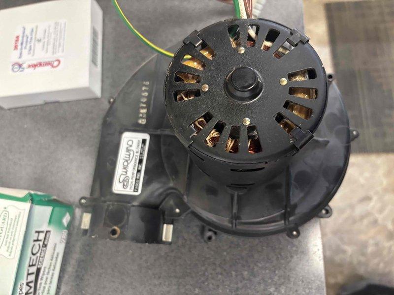 Responded to no heat call at commercial office for 20+ year old system. Diagnosed failed inducer motor, evidenced by compromised copper windings visible through ventilation slots. Installed replacement Fasco inducer motor, restoring system function. Advised customer about discussing furnace replacement with landlord due to system age.