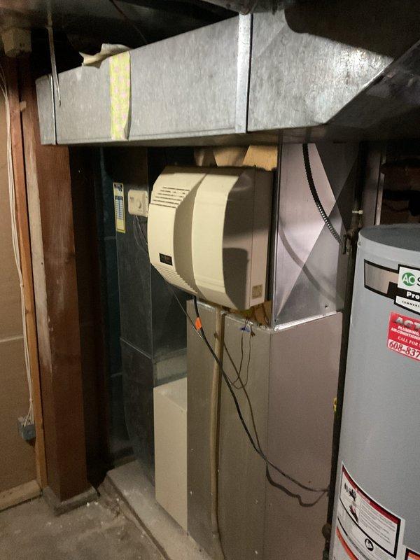 Successfully reinstalled customer's existing Aprilaire Model 700 automatic humidifier that was previously hanging by the water line. Mounted unit securely to the furnace ductwork, reconnected electrical components using proper wire connections, and verified system operation.