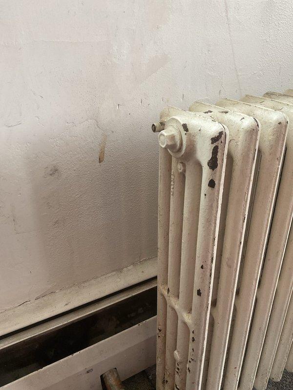 Responded to no heat complaint in room 402. Diagnosed air trapped in heating line of cast iron radiator. Successfully bled air from the system and verified proper operation of the radiator. Confirmed thermostat was functioning correctly and set to 60°F heat mode.