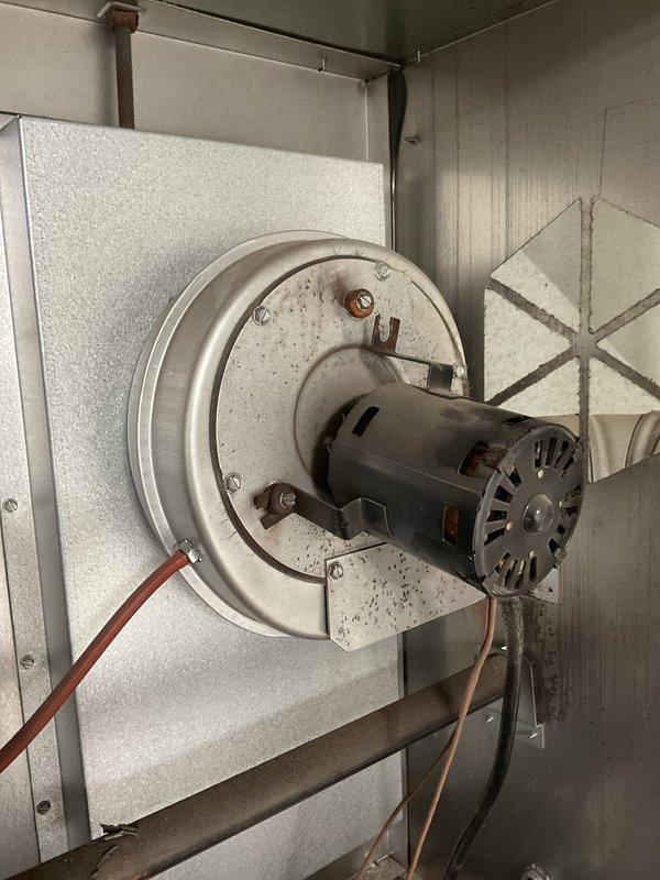 Responded to service call for unit heater not working in mechanic shop. Inspected Fasco blower motor assembly which showed signs of failure. Motor was found mounted on circular plate within HVAC equipment housing with visible dust accumulation and wear. Service restored heating functionality to the unit.