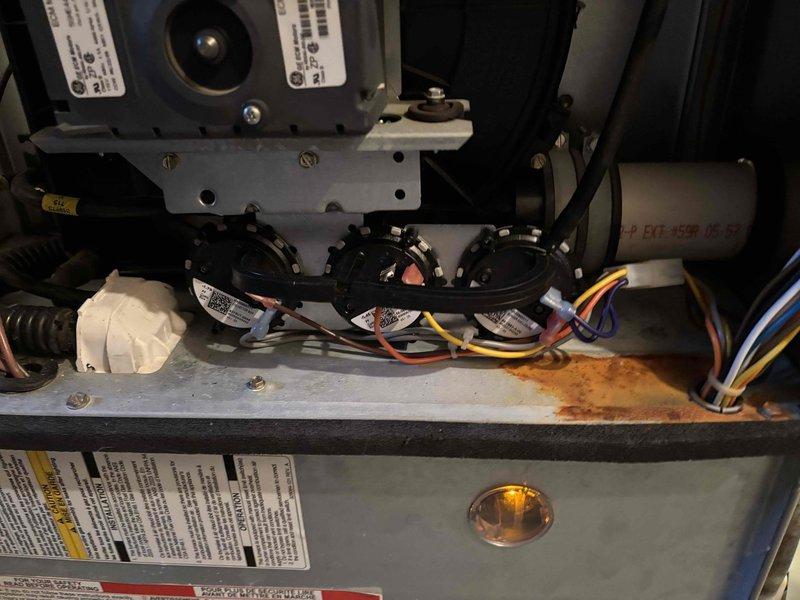 Diagnosed and replaced faulty pressure switch on aging Carrier Infinity furnace that was experiencing no-heat condition. Visual inspection revealed corrosion at wiring connections, indicating moisture exposure and component deterioration consistent with system age. Installation of new pressure switch restored proper system operation and heating functionality.