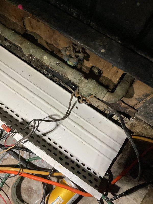 Responded to no heat complaint in Room 002. Discovered frozen radiator due to open window near unit and cold air infiltration from air conditioner. Found damaged zone valve locked in open position and thermostat detached from wall. Temporary heat source placed near radiator to address immediate heating needs. Return visit scheduled to replace zone valve top and install new thermostat.