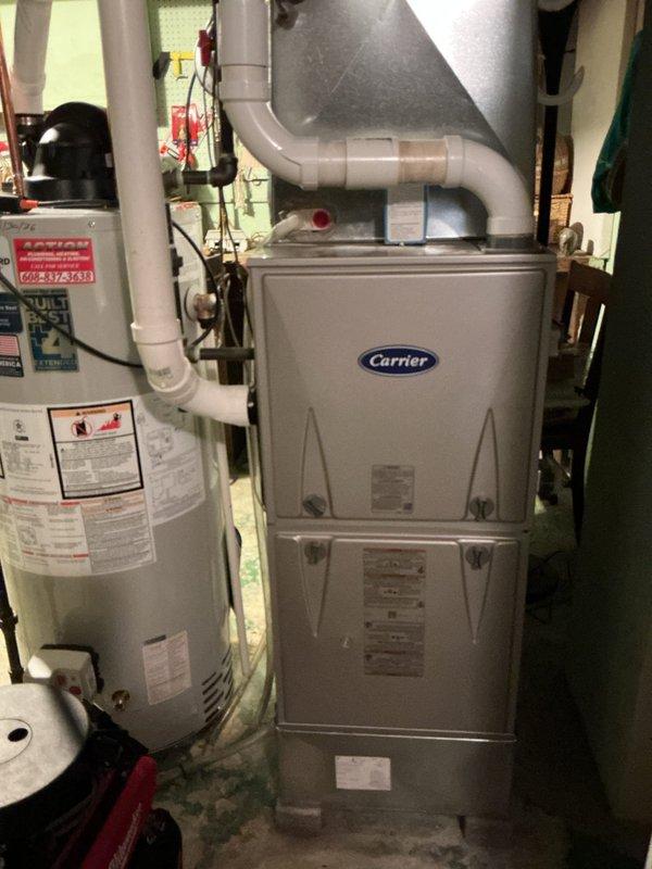 Responded to a carbon monoxide concern where occupants reported feeling ill when basement furnace was running. Inspected Carrier furnace system and water heater installation. CO testing performed with all readings within normal range; no carbon monoxide leak detected.