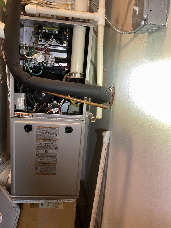 Responded to service call for water leakage from furnace. Upon inspection of the high-efficiency unit, diagnosed condensate drainage issue. Removed front panels to access internal components, cleaned blocked drain line, and verified proper drainage system function. System now operating normally with no leaks detected.