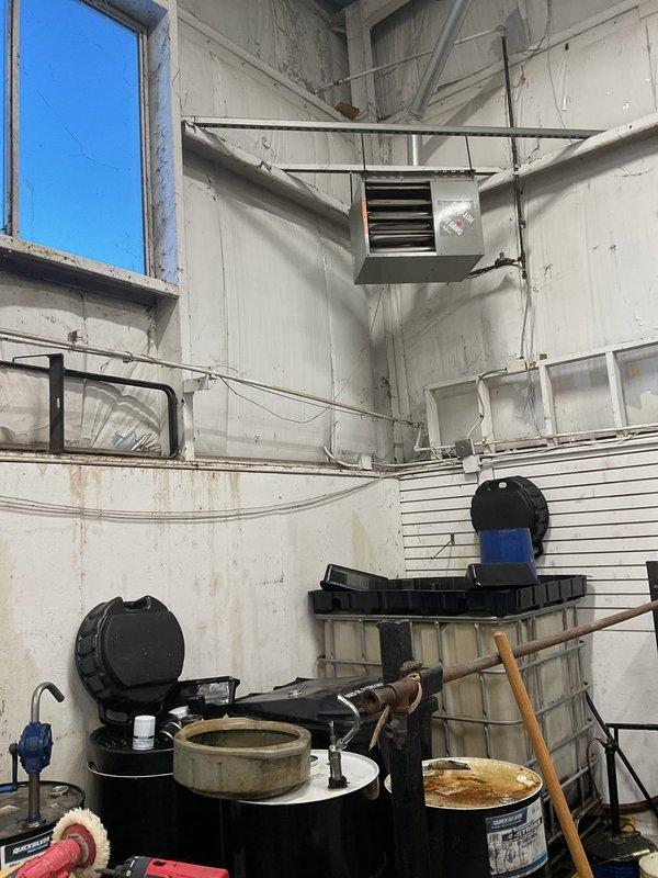 Diagnosed two non-operational heating units in industrial workspace. Inspected ceiling-mounted ventilation/heating system with louvers and wall-mounted heating unit with vents. Units require repair to restore proper heating function in this utility area.