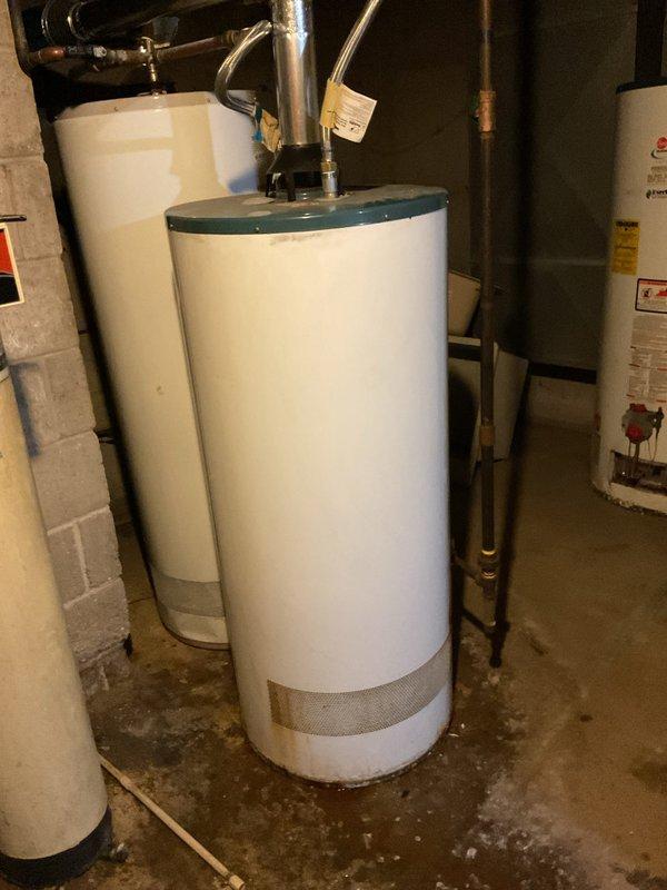 Responded to no-heat call at 4-unit apartment complex with 2005 RUUD Guardian System water heater exhibiting active leak. Visual inspection confirmed failure requiring complete replacement of aging unit. New EverKleen self-cleaning water heater was installed with all necessary plumbing connections to restore hot water service to all units.