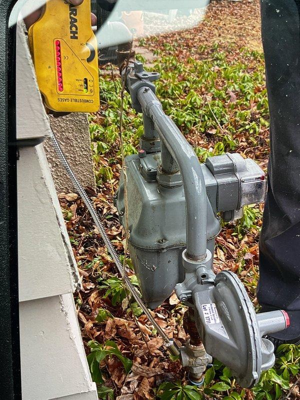 Responded to report of gas odor near furnace and water heater. Conducted leak detection and identified gas leak at meter valve. Documented condition with photos showing valve assembly and testing equipment. Contacted local utility (MG&E) as required per safety protocols.