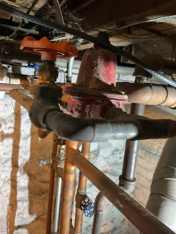 Responded to no heat call for steam radiator system. Diagnosed empty boiler as the root cause. Refilled boiler and discovered faulty pressure gauge, which was confirmed when the pressure relief valve activated prematurely before system reached normal operating temperature.