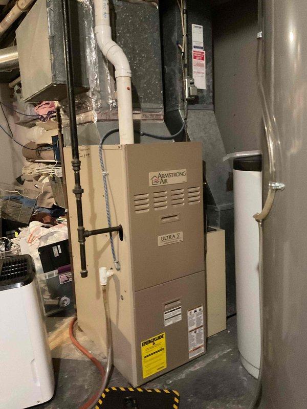 Diagnosed and resolved temperature maintenance issue on main floor HVAC unit which was short-cycling due to a partial blockage in the condensate drain line. Performed standard tune-up on both furnace units, including cleaning pressure switch ports, resulting in improved operation despite lower-than-optimal vacuum readings (0.119 vs standard 0.75). Replaced batteries in both thermostats and verified CO readings (10 ppm on bedroom furnace, 15 ppm on main furnace) were within acceptable limits.