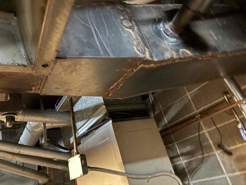 Responded to service call for noisy exhaust fan in furnace system. Inspected HVAC ductwork in utility space and found deterioration along metal seams with visible rust/corrosion contributing to operational noise. Serviced and repaired affected components to eliminate the noise issue.