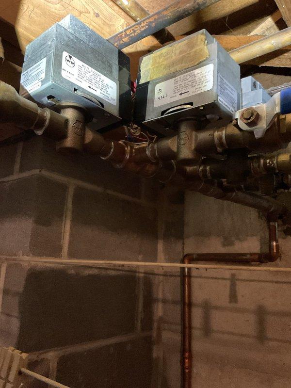 Responded to building overheating issue caused by malfunctioning zone valve control on baseboard heating system. Diagnosed miswired thermostat connections causing zone valve actuator to continuously rotate, preventing proper temperature regulation throughout the building. Disconnected faulty zone valve and two thermostats from the system to restore proper heating control and eliminate overheating condition.