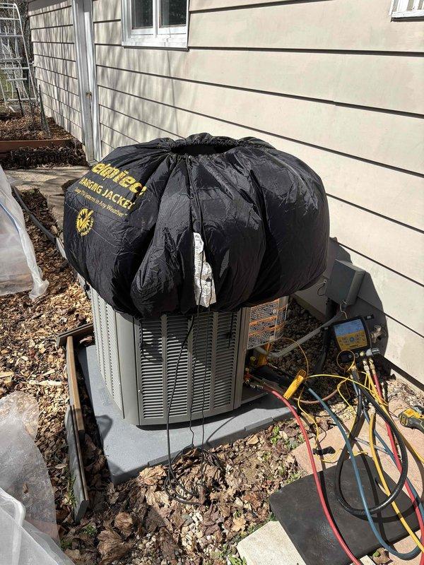 Performed seasonal air conditioning startup and system inspection. Connected manifold gauge set to outdoor condenser unit to verify refrigerant pressures and system operation. Utilized digital temperature measurement tools to check supply and return air temperatures, confirming proper cooling differential. Addressed customer inquiry regarding previously repaired heating system. Verified outdoor unit had protective winter cover in place, which was removed for seasonal startup. All system parameters checked and found operating within normal specifications.