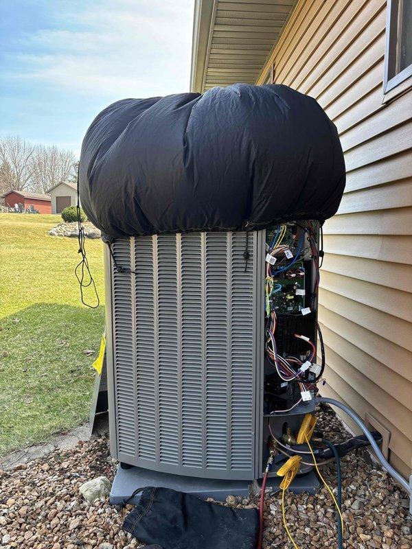 Performed seasonal air conditioning start-up service on outdoor condensing unit. Removed access panel to inspect internal electrical components and control board, verified all connections and wiring integrity, and confirmed system readiness for cooling season operation.