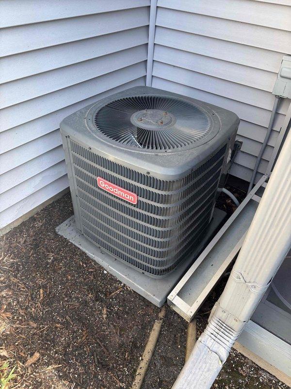 Completed prepaid cooling maintenance visit on Goodman outdoor condensing unit. Performed standard seasonal maintenance inspection and testing procedures. Connected diagnostic manifold gauges to measure system pressures and temperatures across the refrigerant circuit. Recorded operating parameters including suction and discharge pressures, subcooling, and superheat values to verify proper refrigerant charge and system performance. Unit operating within normal specifications at time of service. Condensing unit exterior showed typical weathering with accumulated dirt and debris on coil surfaces and cabinet. Documented equipment condition and system readings with photos for service records.