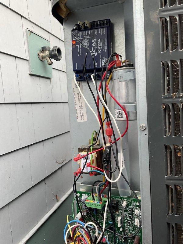 Installed low ambient control kit on outdoor condensing unit to enable system operation during cooler outdoor temperatures. Mounted ComfortAlert circuit board inside control panel, wired control module to existing capacitor and electrical components, and secured all connections with appropriate wire nuts and cable management. System tested and verified operational with new low ambient control functioning properly.