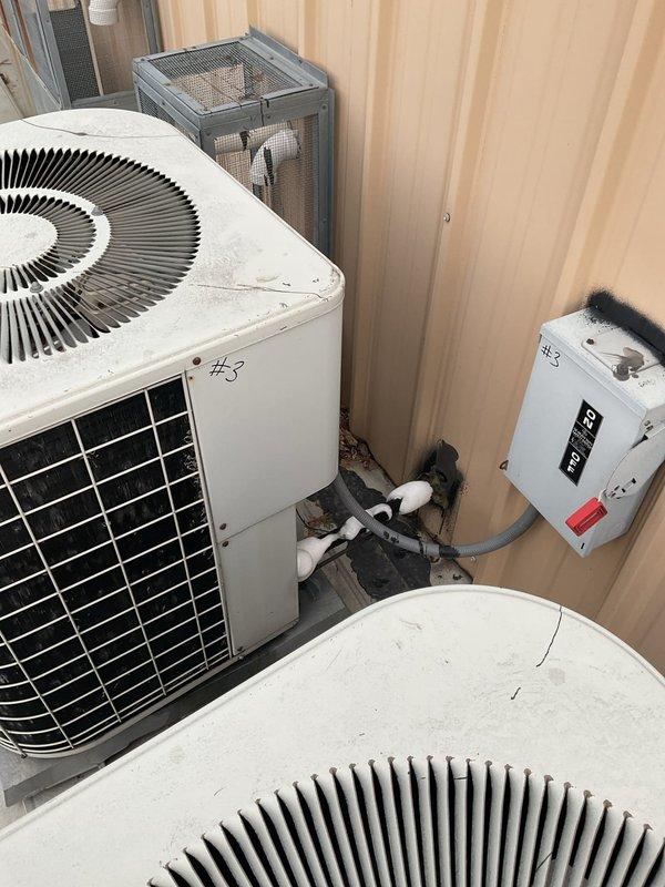 Responded to service call for non-operational air conditioning system with water discharge from furnace cabinet. Upon arrival, inspected multiple outdoor condenser units and indoor air handler assembly. Identified condensate drain blockage causing water overflow from furnace main body. Cleared obstruction from condensate line, verified proper drainage flow, and tested system operation. All three condenser units (#3 marked units) confirmed operational with proper refrigerant flow and electrical connections secure at disconnect boxes. System restored to normal cooling operation with no further water leakage observed.