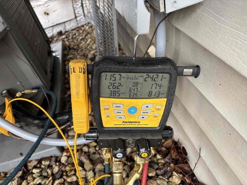 Completed comprehensive AC tune-up and cleaning service on outdoor condensing unit. Performed system diagnostics using digital manifold gauges, measuring refrigerant pressures and temperatures to verify proper operation—readings indicated system operating within normal parameters. Cleaned exterior condenser coils and housing, removing accumulated dirt, debris, and mineral deposits from weathered cabinet panels. Unit tested and confirmed operational with acceptable performance metrics.