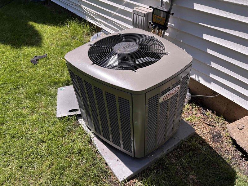 Completed scheduled air conditioning maintenance and inspection on Lennox outdoor condensing unit. Performed comprehensive clean and check service including visual inspection of cabinet, fan assembly, and electrical components. Unit showed signs of extended exposure and accumulation of dirt and debris on exterior panels and base. Cleaned condenser coils, removed organic material and debris from unit base and surrounding pad area. Verified proper operation of condenser fan motor and compressor. Checked electrical connections at disconnect box and confirmed secure conduit routing. Inspected refrigerant lines for damage or deterioration. System tested and operating within normal parameters. Maintenance complete with no deficiencies noted requiring immediate attention.