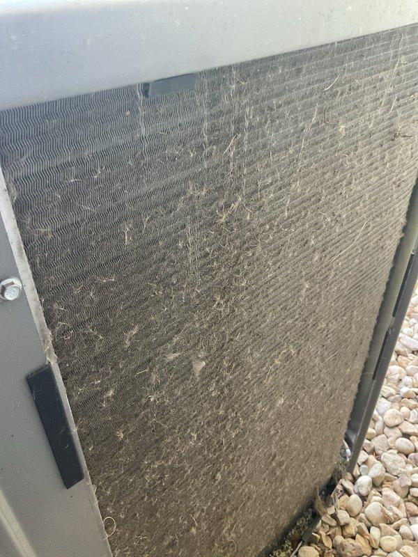Performed preventative maintenance inspection and cleaning on a two-year-old residential air conditioning system in preparation for cooling season. Upon arrival, conducted thorough examination of outdoor condenser unit, which showed significant accumulation of dirt, dust, and debris throughout the condenser coils and fins despite relatively new equipment age. Removed access panels to assess internal components and coil condition. Performed complete cleaning of condenser coils to remove heavy buildup that had collected across the finned surfaces, restoring proper airflow and heat transfer efficiency. Verified all mechanical components, electrical connections, and refrigerant lines were in good working order with no deficiencies noted. Unit operational status confirmed satisfactory with no repairs required at this time.