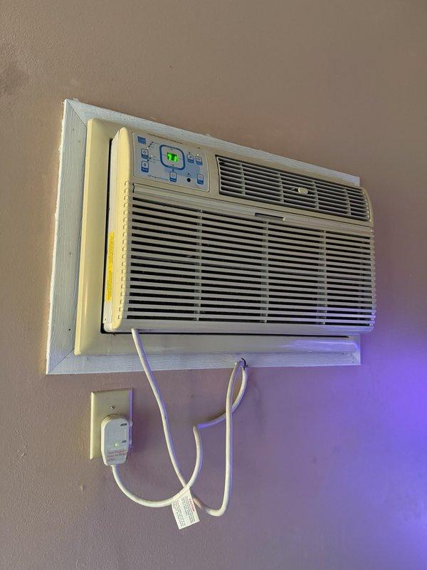 Completed installation of customer-provided through-the-wall air conditioning unit. Customer had begun the installation but required professional assistance to properly complete the mounting, secure the unit within the wall opening, establish electrical connection to existing outlet, and verify operational functionality. Unit is now fully operational with digital controls displaying proper temperature settings.