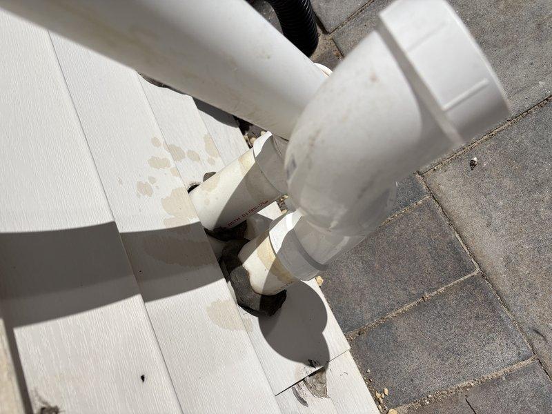 Responded to callback for air conditioning system that was relocated in March. Upon inspection, discovered inadequate sealing around refrigerant line penetrations through basement wall, allowing visible daylight and air infiltration. Properly sealed all pipe penetrations where copper refrigerant lines pass through the foundation wall using appropriate weatherproofing materials to prevent air leakage and maintain building envelope integrity. Verified all seals were complete and inspected exterior PVC condensate drain routing on roofline to ensure proper drainage function.