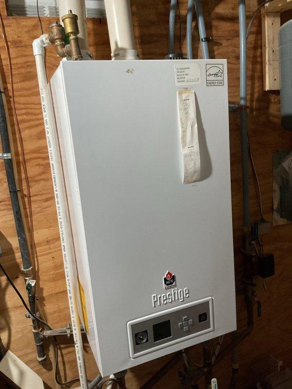 Performed comprehensive boiler tune-up and safety inspection on Prestige tankless boiler system. Cleaned dirty igniter and trap, replaced faulty Schrader valve on expansion tank to restore proper system pressurization. Completed air conditioning clean and check service, diagnosed low refrigerant charge and recharged system to manufacturer specifications after addressing refrigerant leak concerns.