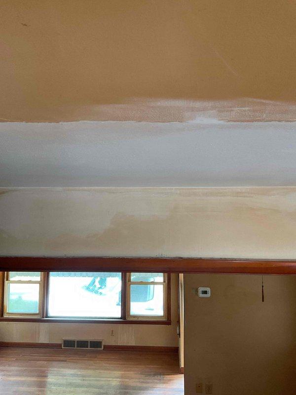 Completed drywall repair on ceiling damaged during attic access by technician. Removed compromised ceiling material, ground out affected plaster and fiberglass mesh, applied multiple coats of joint compound over three separate visits with intermediate sanding between applications, performed final sanding, and primed repaired area with primer paint to prepare surface for finish coating.