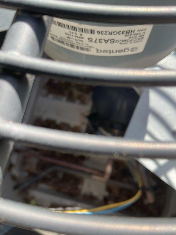 Responded to service call for air conditioning unit not working correctly with loud banging noise from fan or blower motor. Upon arrival, inspected Bryant brand outdoor condenser unit and identified the source of the noise. Performed diagnostic evaluation of the blower motor assembly and fan components through the protective wire guard. Assessed mechanical and electrical connections to determine the cause of the malfunction. Used refrigerant gauges and testing equipment to verify system operation and ensure proper functionality of the unit.