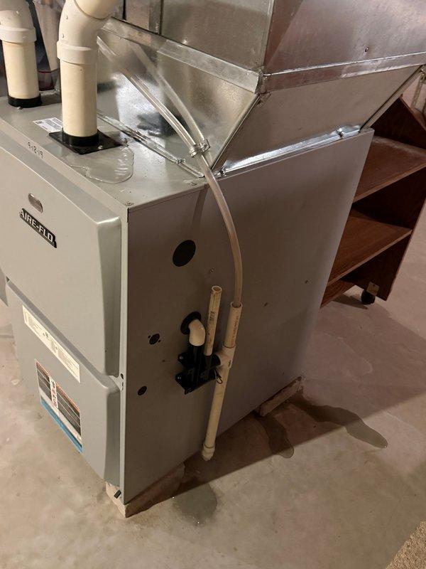 Responded to service call for water pooling on top of furnace unit. Performed comprehensive diagnostic inspection of high-efficiency furnace system and condensate drainage components. Inspected PVC condensate drain lines, trap assembly, and discharge piping for blockages or restrictions. Checked condensate pump operation and verified proper drainage flow. Examined secondary drain pan for cracks or overflow conditions. Inspected evaporator coil drain outlet and surrounding cabinet for moisture intrusion sources. Verified furnace inducer motor and pressure switch operation. Checked flue pipe connections and PVC intake/exhaust venting system for proper sealing and potential condensation leakback. System operational upon completion with proper condensate removal functioning.